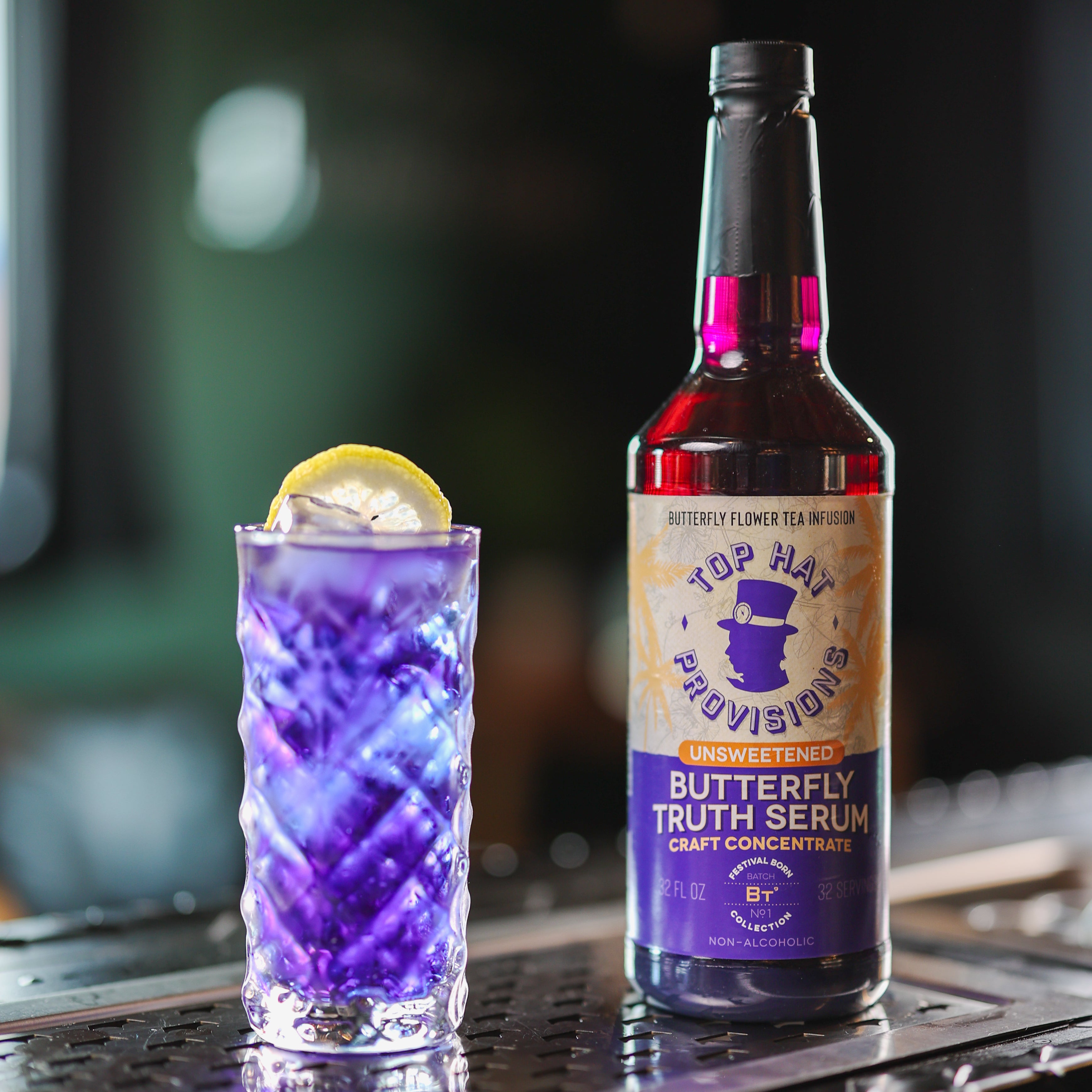 Butterfly bottle behind a bit with tall glass and lemon