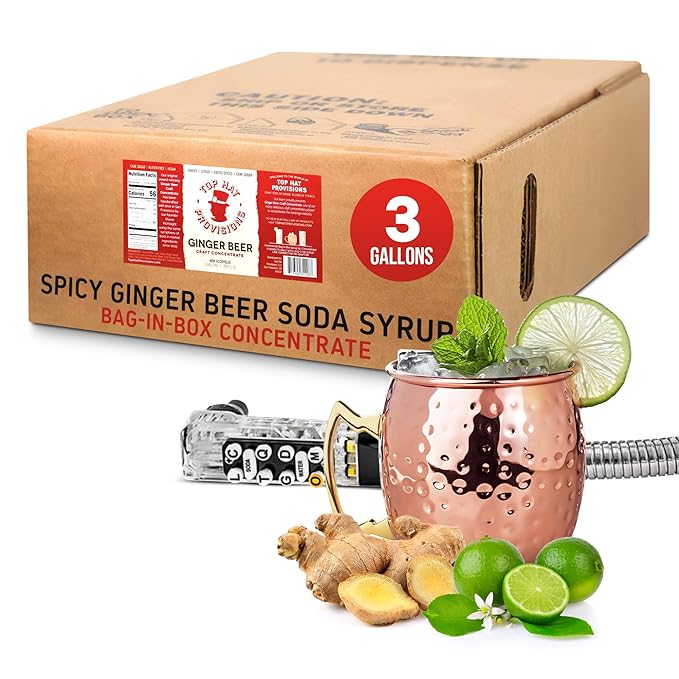 A cardboard box labeled Top Hat Original Ginger Beer Bag in Box Soda Syrup BIB, 3 gallons from Top Hat Provisions sits next to a copper mug for crafting Moscow Mules with lime and mint. Fresh ginger, whole limes, a coiled silver tube, and tap head complete the scene for an authentic mix bursting with organic ingredients.