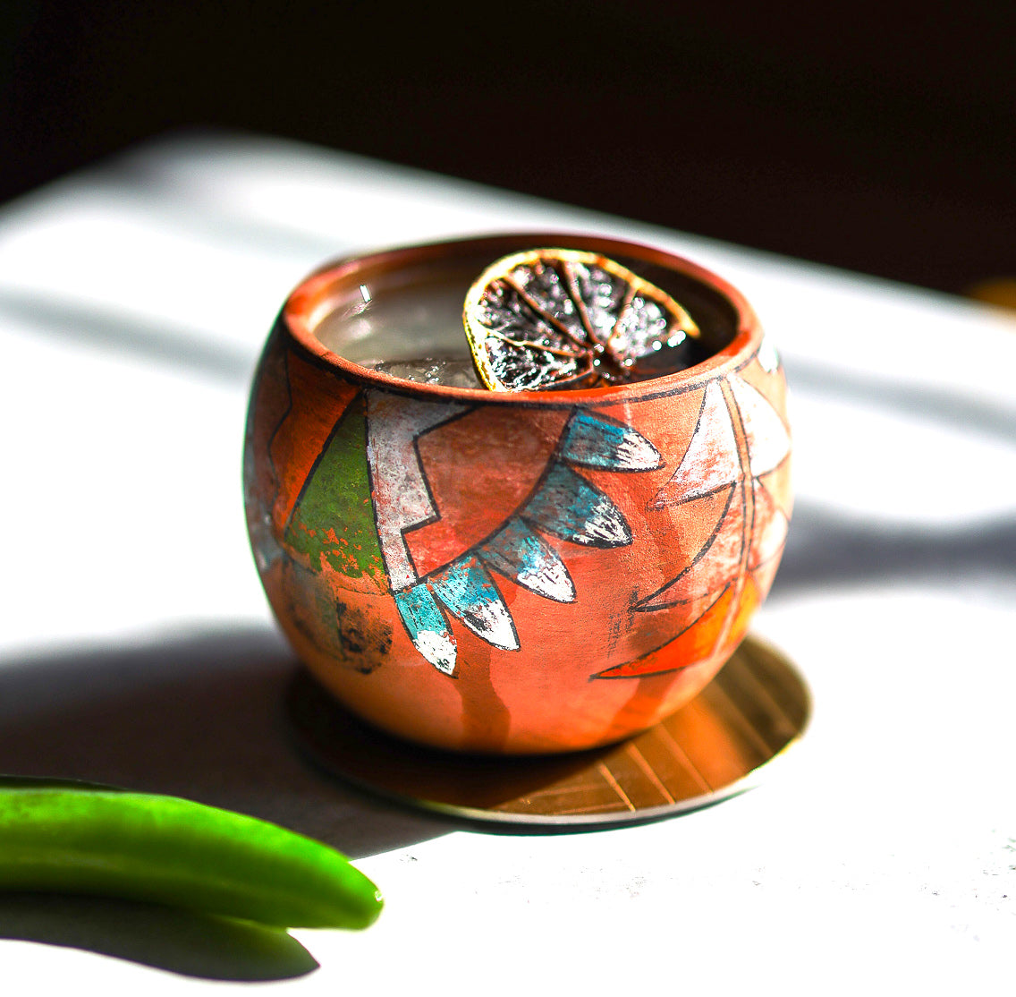 Spicy margarita alone in ceramic painted cup with shadows, higher side view close-up, bright