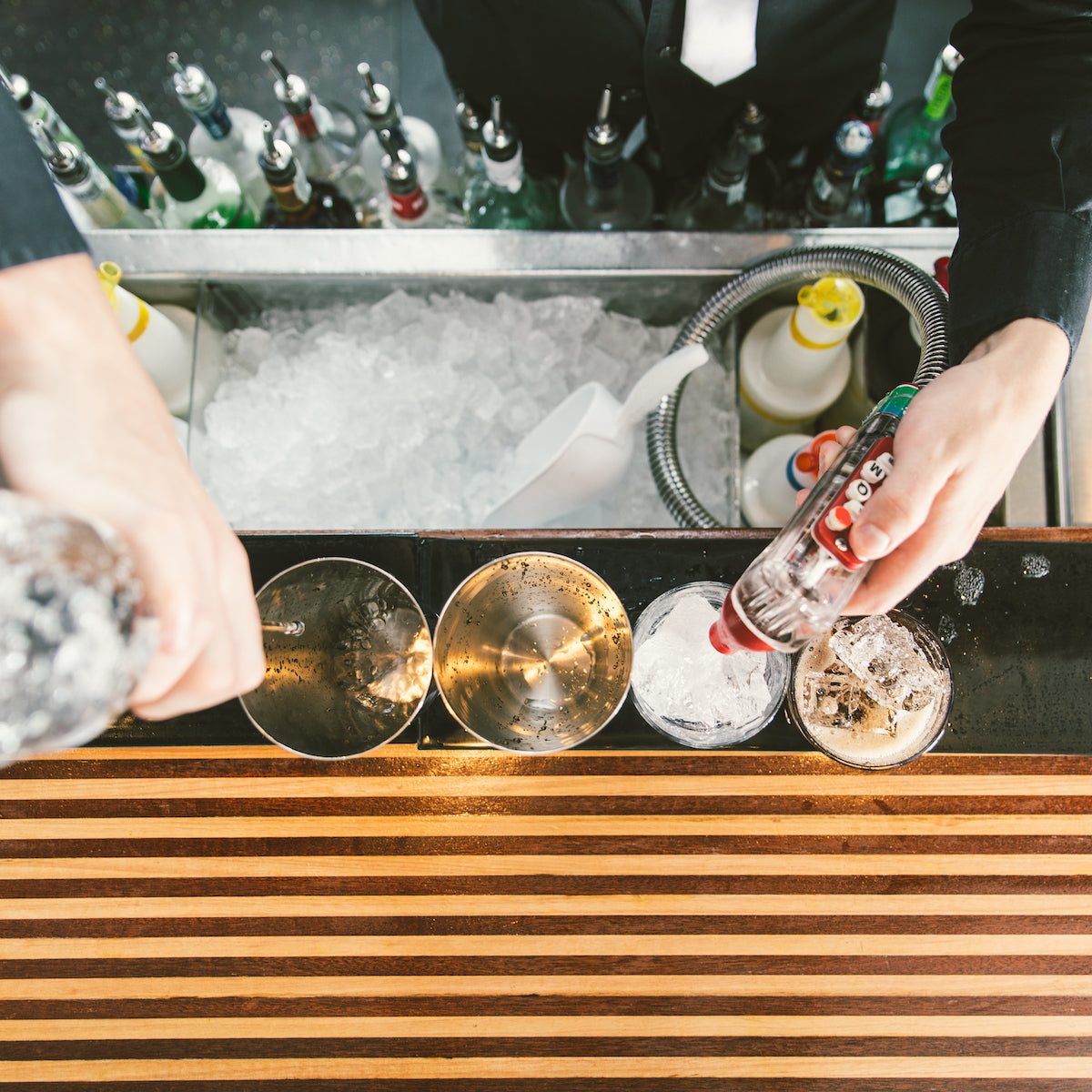 Top down view of soda gun bartender making cocktails, full image, square crop