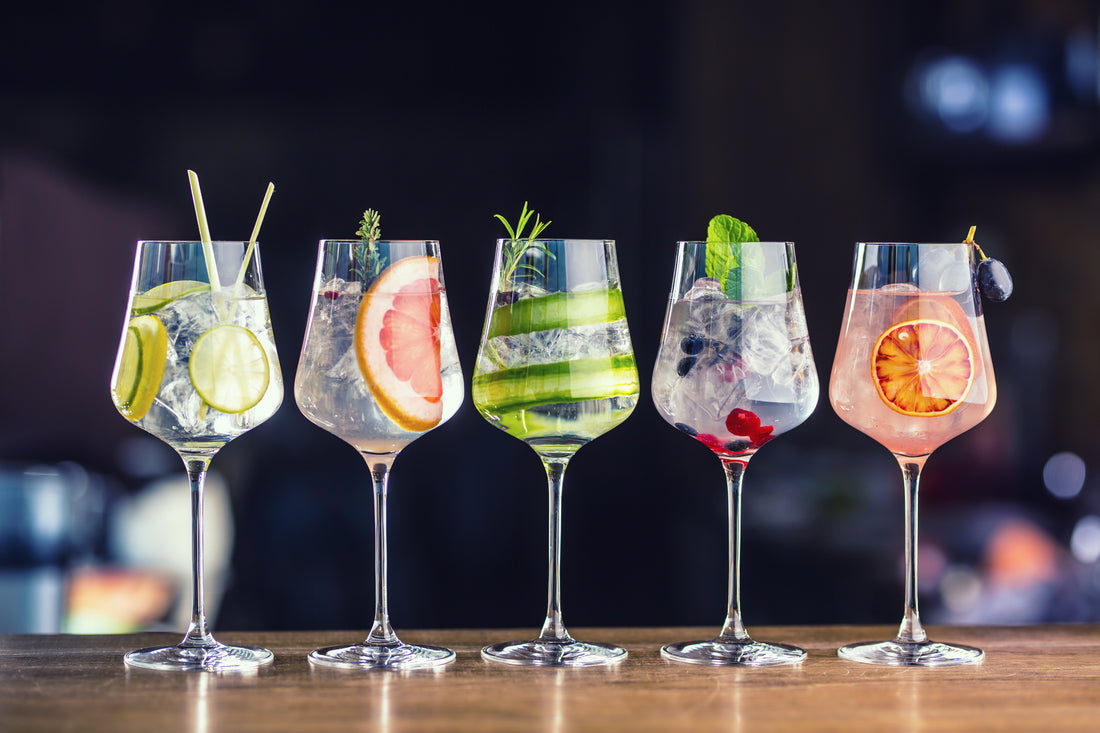 Collection of gin and tonics with fresh colorful garnishes, full image